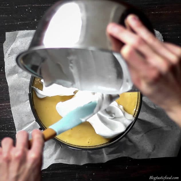 A photo of someone putting meringue on top of lemon curd. 