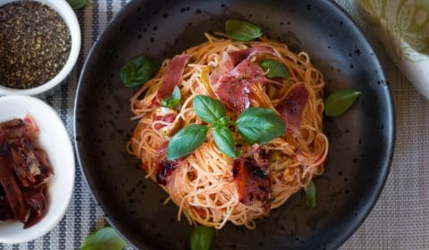 An overhead photo of angle hair pasta with crispy prosciutto. 