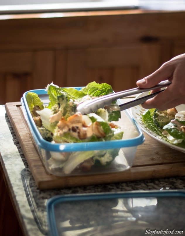 Broccoli Caesar salad being transferred to a container.