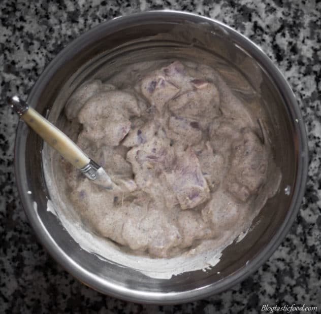 An overhead photo of diced chicken marinating in yogurt and spices.  