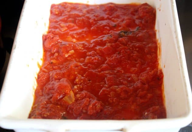 A photo of tomato sauce being spread out in a tray.