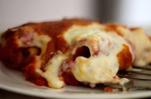 A close up photo of cannelloni on a white plate.