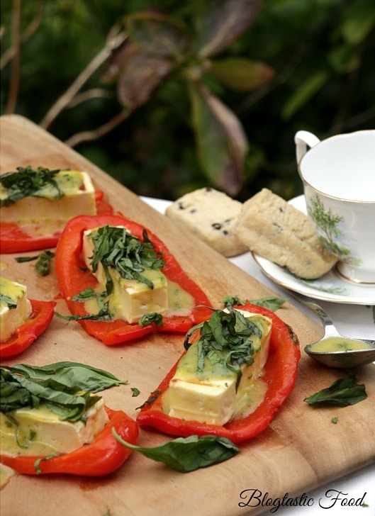 Roasted red peppers with grilled halloumi cheese served on a chopping board.