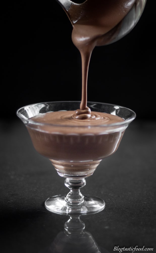 A photo of mint chocolate mousse being ladled into a glass.