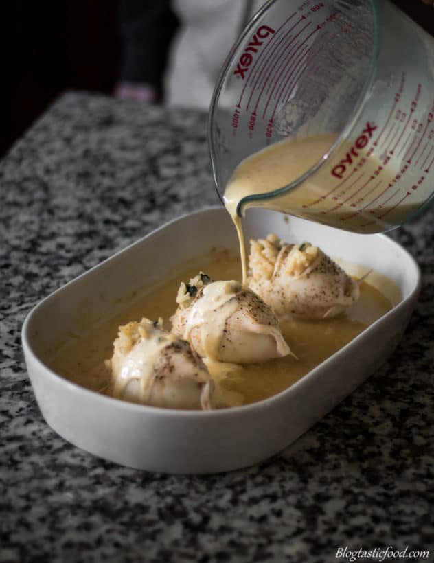 A photo of creamy lemon sauce being poured over baked stuffed squid. 