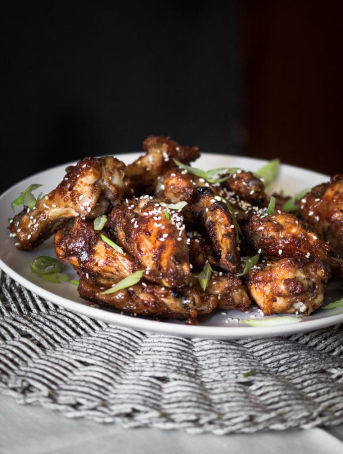 A dark moody photo of spiced and glazed chicken wings.