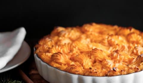 A photo of potato and sweet potato shepherds pie served in a pie dish.