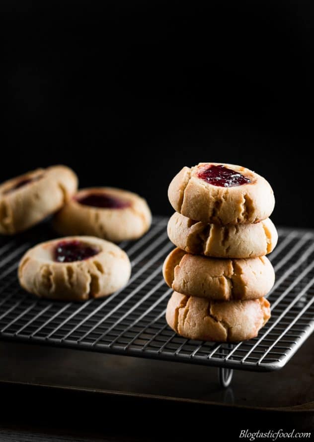 A stack of peanut butter and jam cookies on a wire rack.