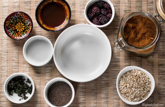 A photo of a white bowl surrounded by other bowls filled with different ingredients.
