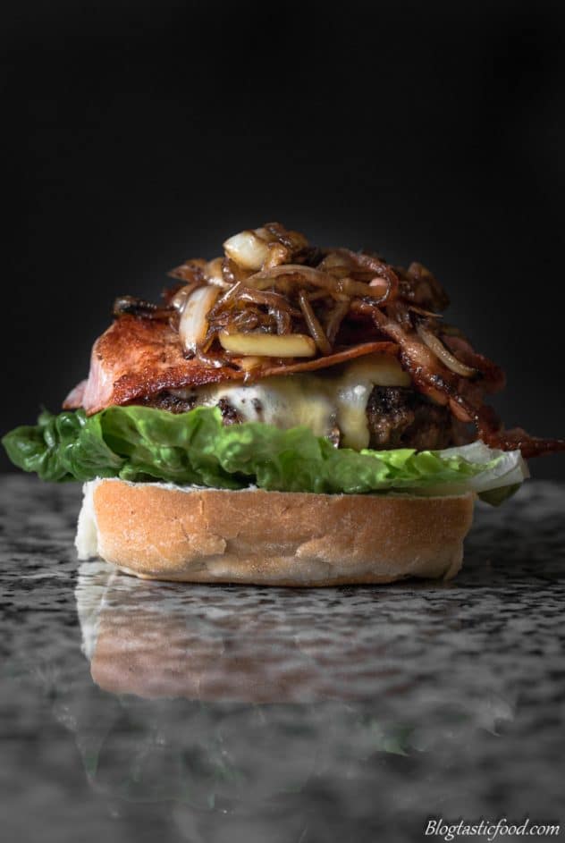 A beef and bacon burger without the top bun. 