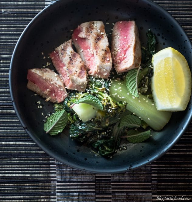 An overhead shot of mixed greens served with seared sliced tuna in a bowl. 