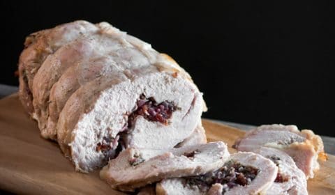 A photo of roasted turkey roll filled with a cranberry and herb stuffing.