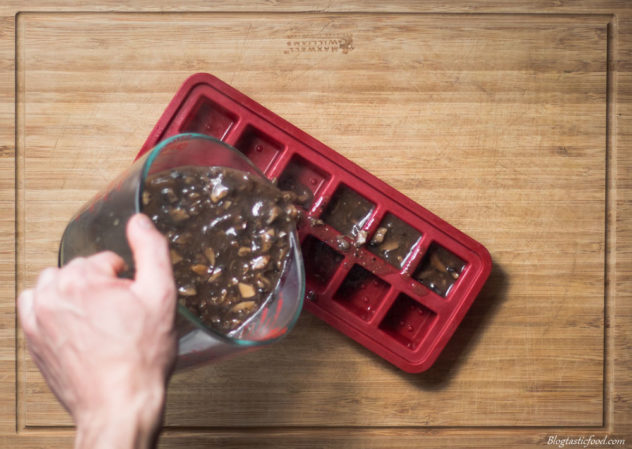 mushroom gravy being poured into an ice cub container.