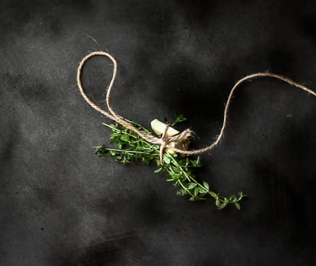 A photo of a bouquet garni on a dark surface.