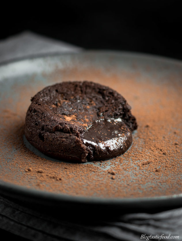 A photo of chocolate lava cake on a plate with the molten oozing out. 