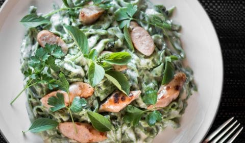 An overhead photo of green sausage pasta.