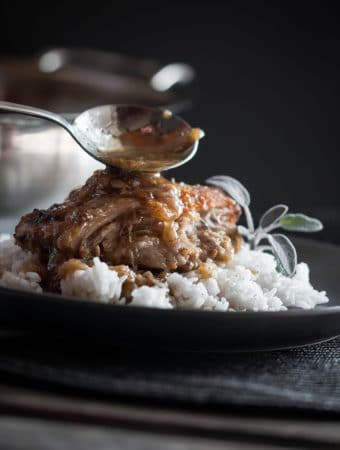 Pork cheeks served on rice and garnished with sage.