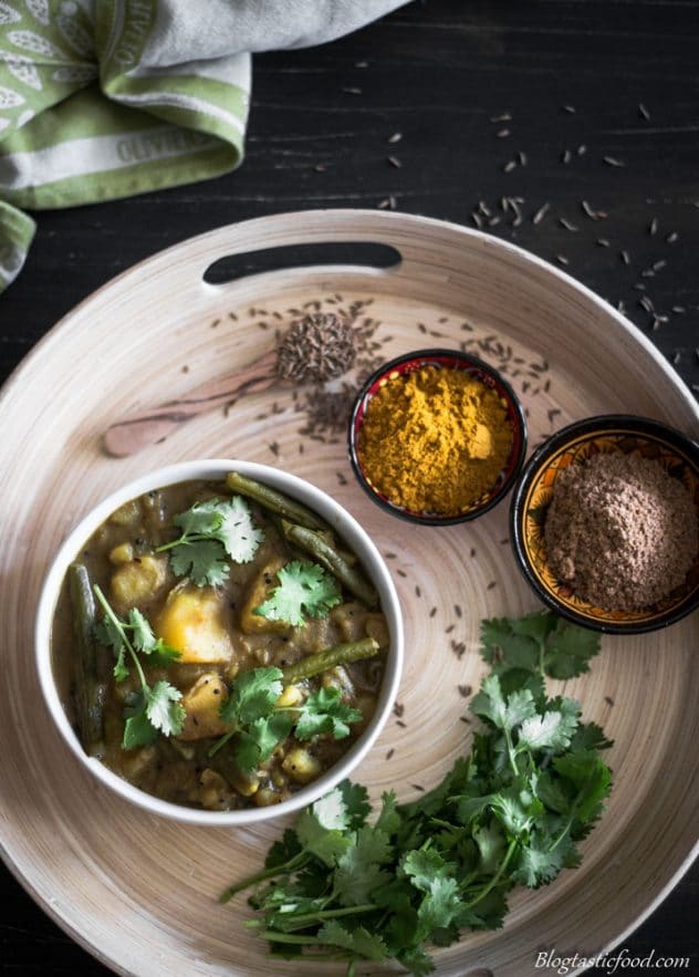 An overhead photo of potato curry coriander and spices.