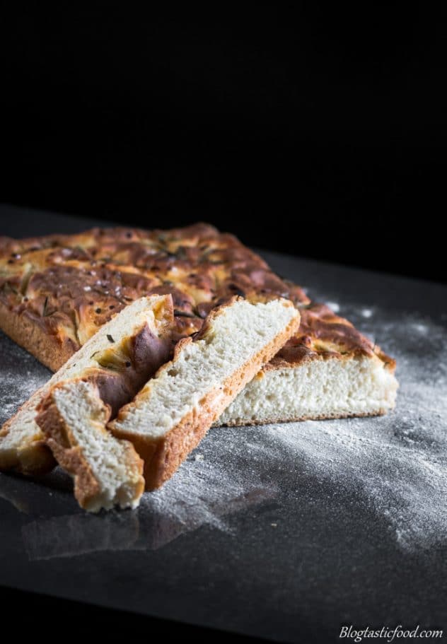 A photo of a loaf of focaccia bread on a flour dusted surface. 