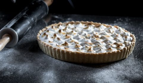 A vegan lemon meringue pie being caramelised with a blow torch.