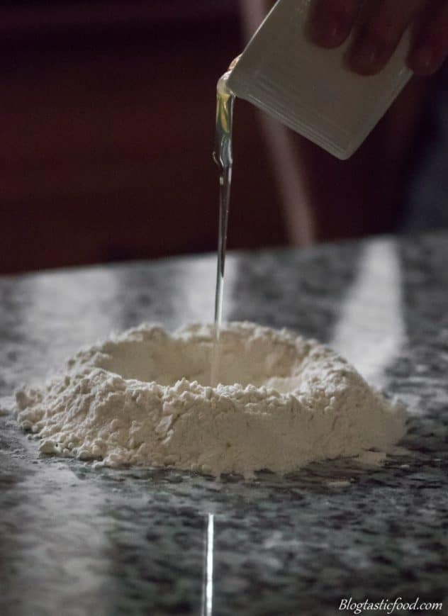 Eggs being added to a well of flour.