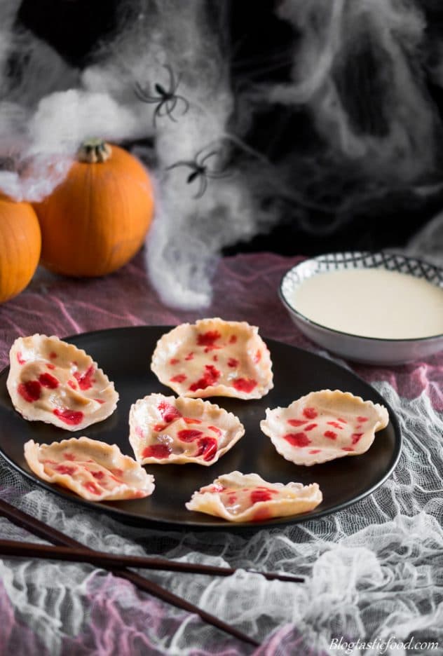 A photo of dessert pumpkin ravioli served on a black plate.