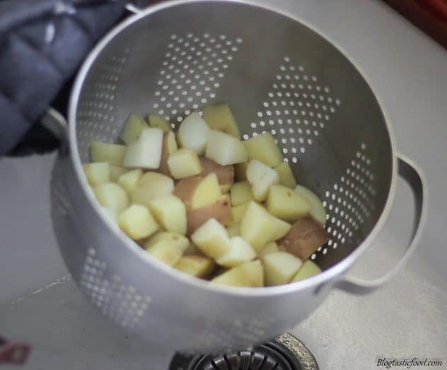 A photo of of par-boiled potatoes in a colander.