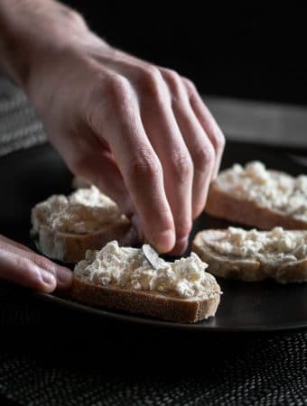 A photo of ricotta cheese being spread over