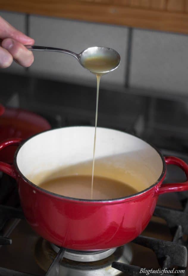 A photo of someone drizzling salted caramel sauce in a pot.
