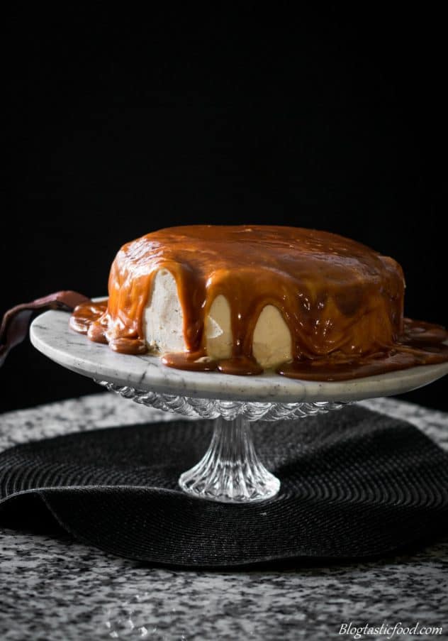 A photo of a salted caramel and baileys frosting cake on a cake stand.