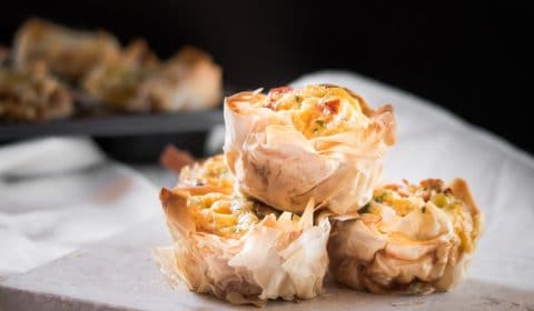 A photo of filo pastry filled mini quiches in a white slate.