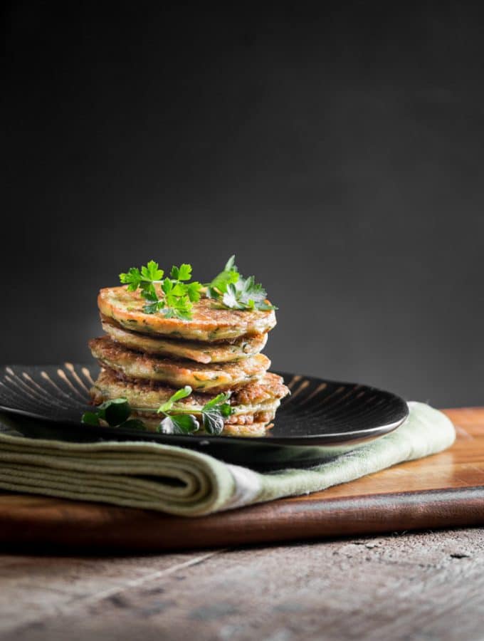 A group of zucchini fritters stacked on top of each other.