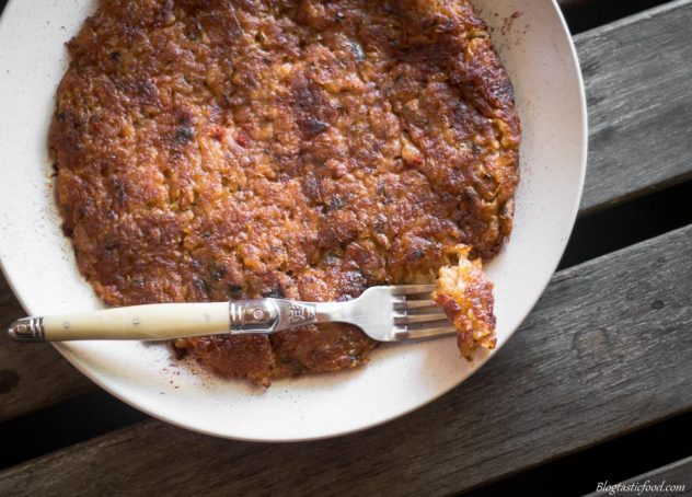 An overheat photo of a large hash brown served on a white plate.