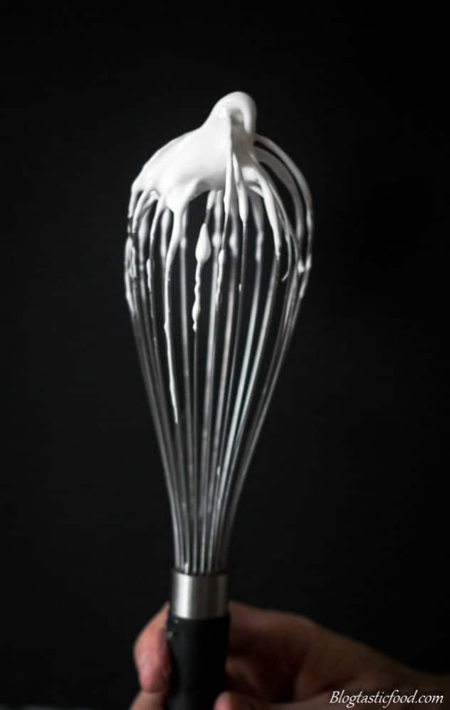 A photo of raw meringue on a whisk.