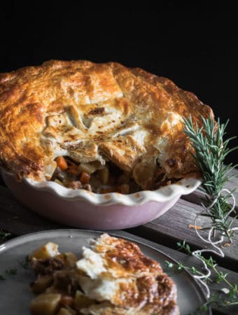 A photo of a Irish stew pie for St Patricks Day with herbs scattered around it.