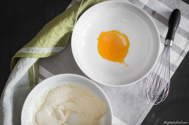An over head photo of a bowl of split mayo, and a bowl with an egg yolk in it.