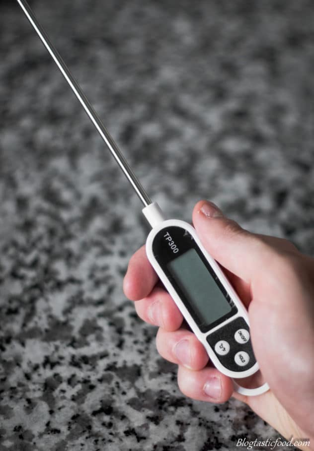 A photo of someone holding a digital thermometer.