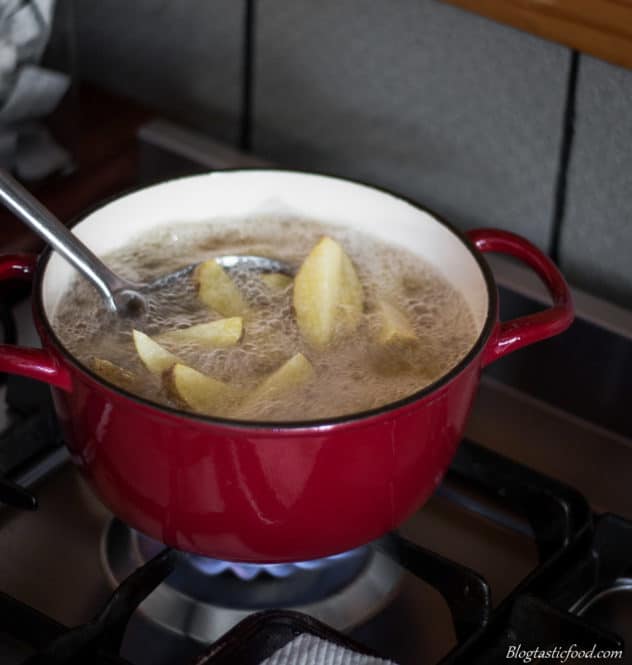 A photo of potatoes frying in a pot of oil.