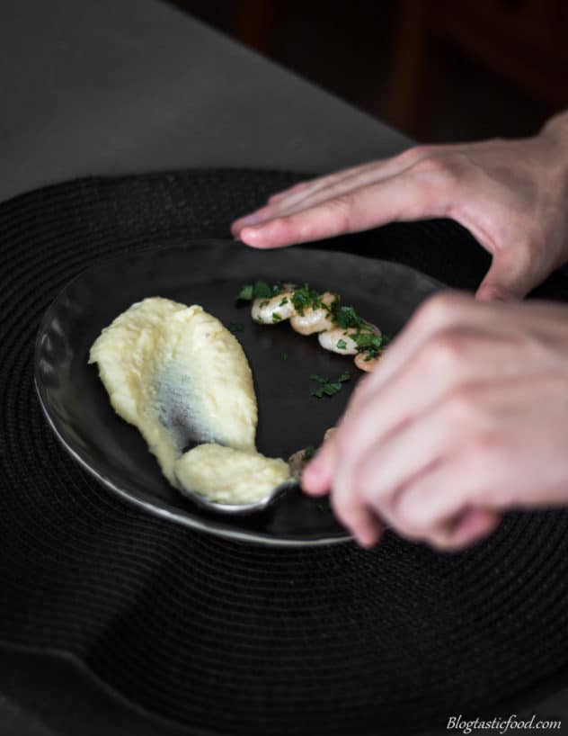 A photo of someone smearing potato puree on a plate.