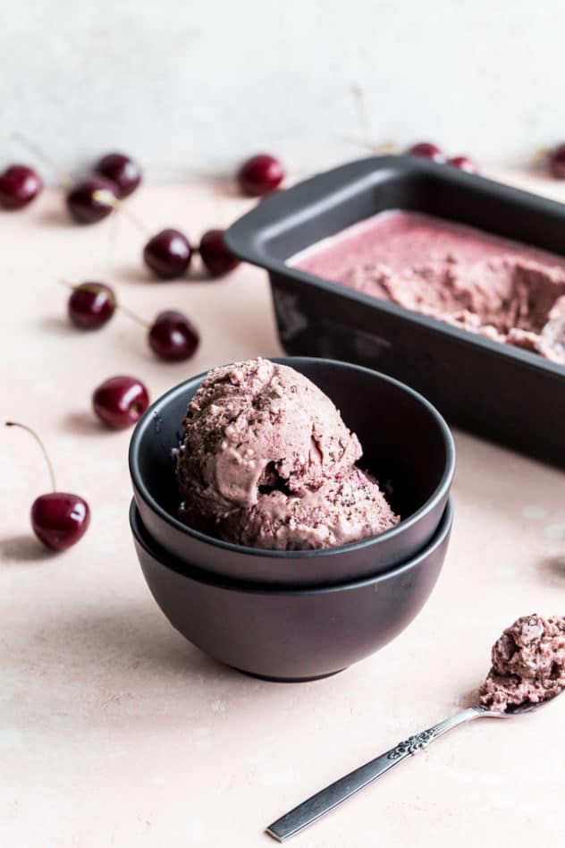 Cherry chocolate chip nice cream served in a black bowl.