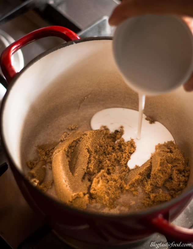 Coconut cream being added to a pot filled with brown sugar.