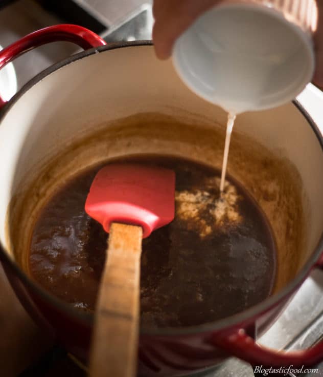 A photo of a slurry being added to vegan butterscotch sauce.