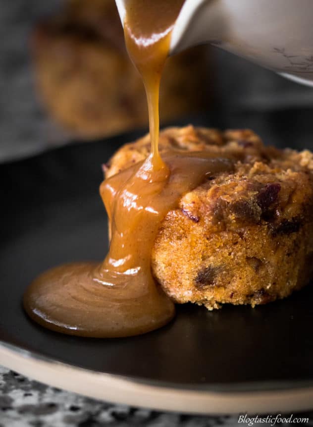 A photo of butterscotch sauce being poured over a mini steamed sticky date pudding.