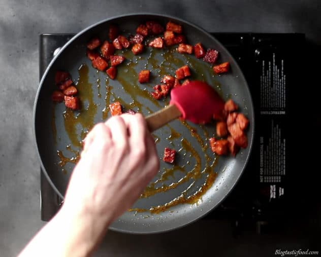 A photo of chorizo frying in a pan.