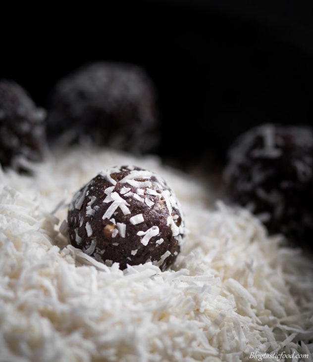 A photo of a protein ball on a pile of shredded coconut.