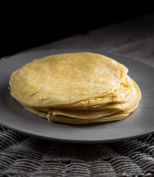 dhal puri stacked up on a grey flat plate.