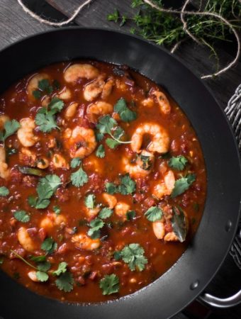 Prawn Rougaille served in a wok, garnished with parsley.