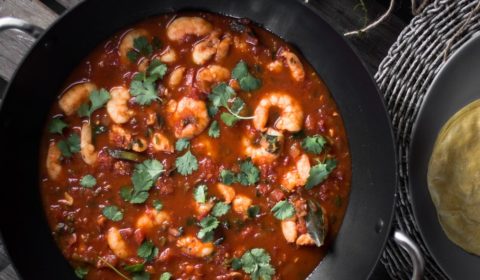 Prawn Rougaille served in a wok, garnished with parsley.