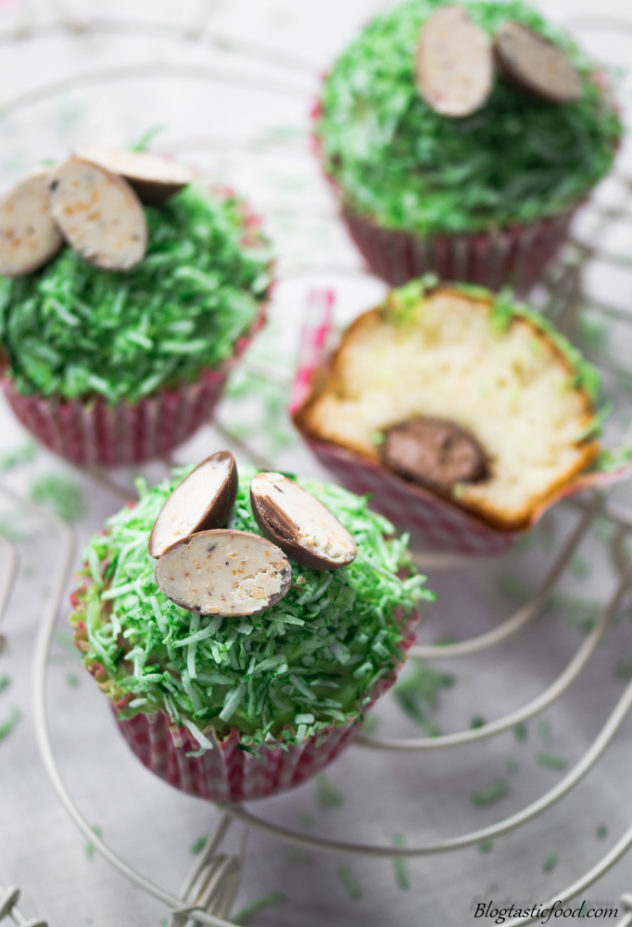 Easter egg filled cupcakes with green icing, garnished with hazelnut Easter eggs.