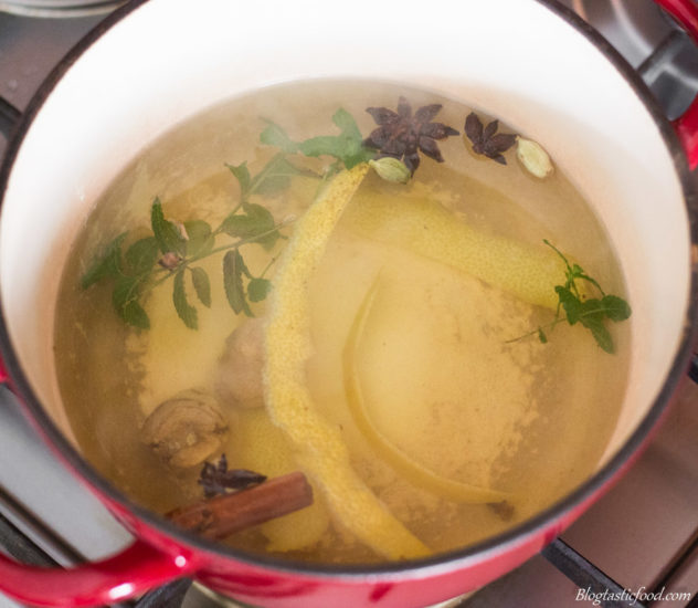 A mixture of herbs and aromatics infusing in a pot of hot water.